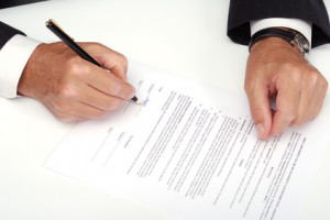 Businessman with black pen signing contract.